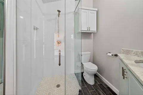 a bathroom with a sink a toilet and shower