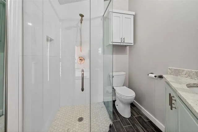 a bathroom with a sink a toilet and shower