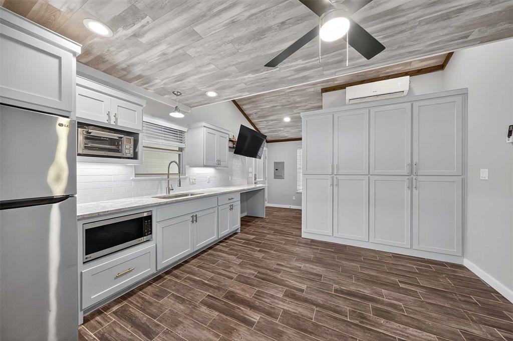 22227 Mallards Cove Bullard, TX 75757 - Photo 33 of 39 a large kitchen with stainless steel appliances granite countertop a stove a sink and a refrigerator