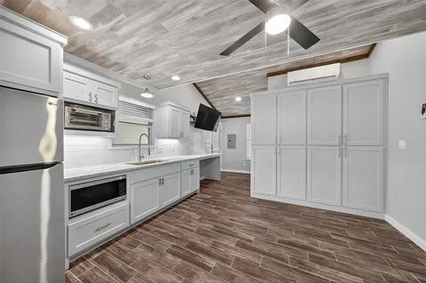 a large kitchen with stainless steel appliances granite countertop a stove a sink and a refrigerator