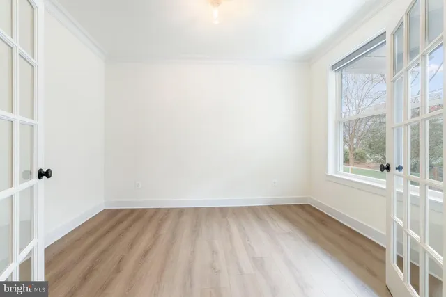 a view of a room with wooden floor and a window