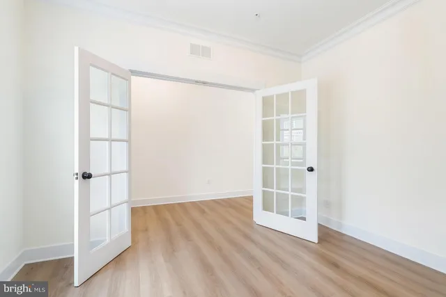 a view of an empty room with wooden floor