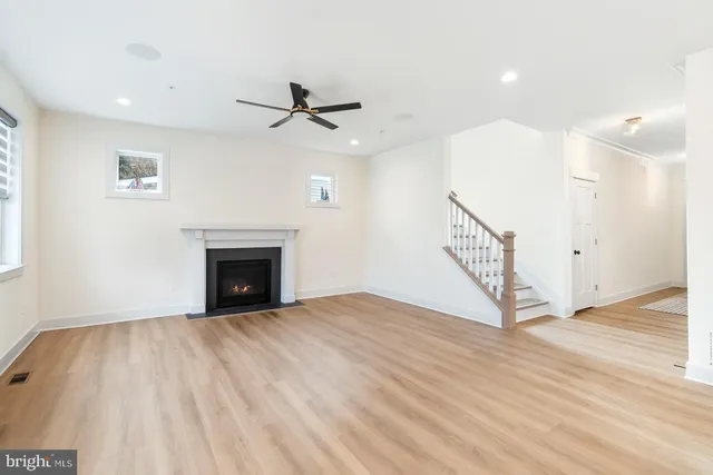 a view of empty room with wooden floor and fireplace