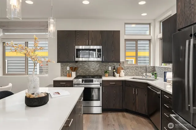 a living room with furniture kitchen view and a large window