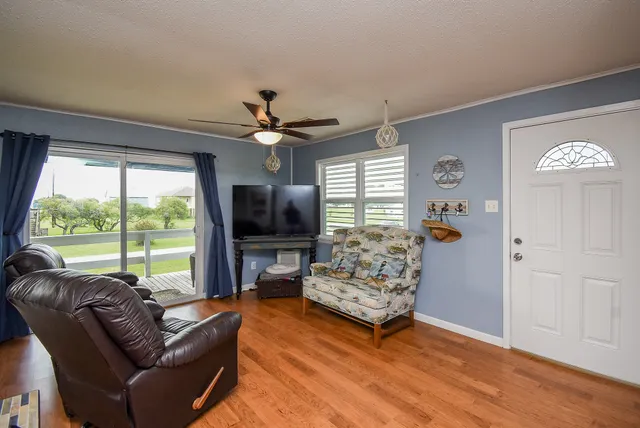 a living room with furniture a flat screen tv and a large window