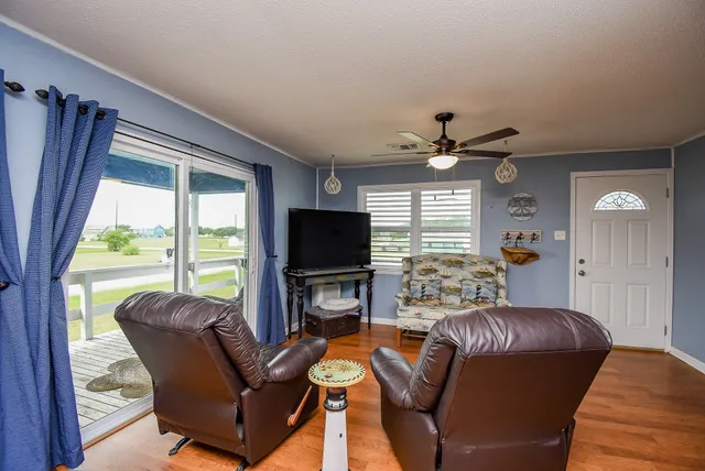 a living room with furniture a flat screen tv and a large window