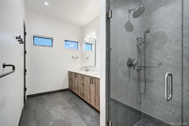 a bathroom with a granite countertop sink a shower and mirror