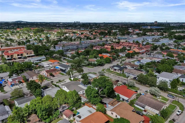 an aerial view of a city with lots of residential buildings ocean and mountain view in back
