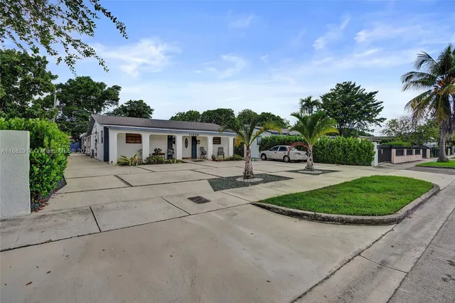 a front view of a house with a garden and plants