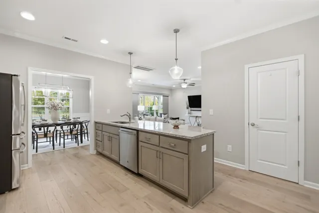 a view of a kitchen with kitchen island granite countertop wooden floor and a window