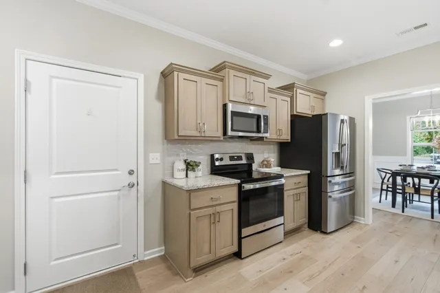 a kitchen with a refrigerator stove and wooden cabinets