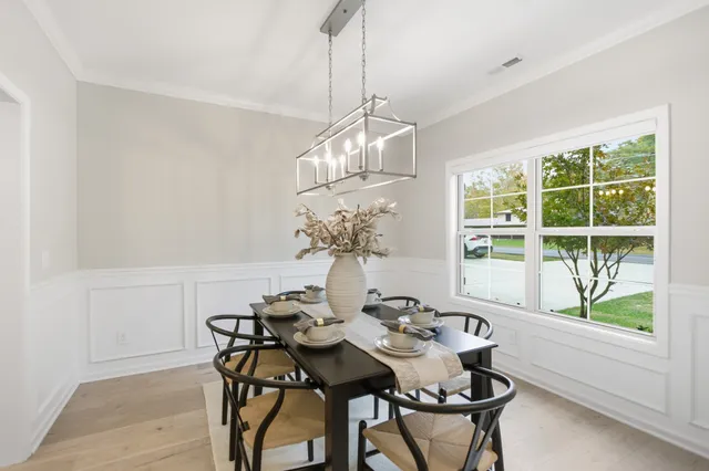 a view of a dining room with furniture wooden floor and chandelier