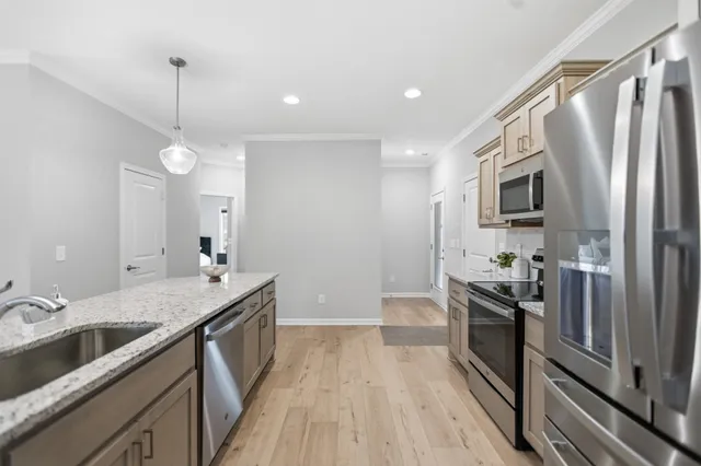 a kitchen with granite countertop a sink appliances and cabinets