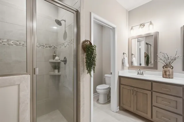 a bathroom with a double vanity sink toilet and shower