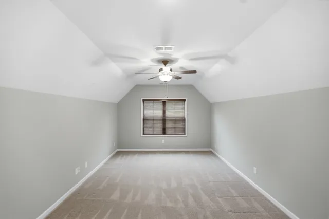 an empty room with windows and chandelier fan