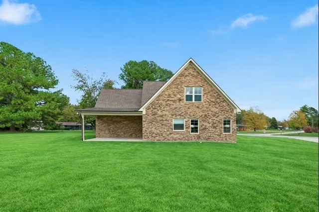 a view of a house with a yard and sitting area
