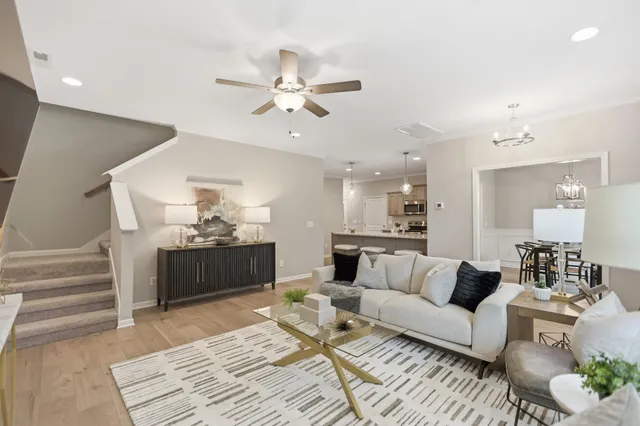 a living room with furniture and a view of kitchen