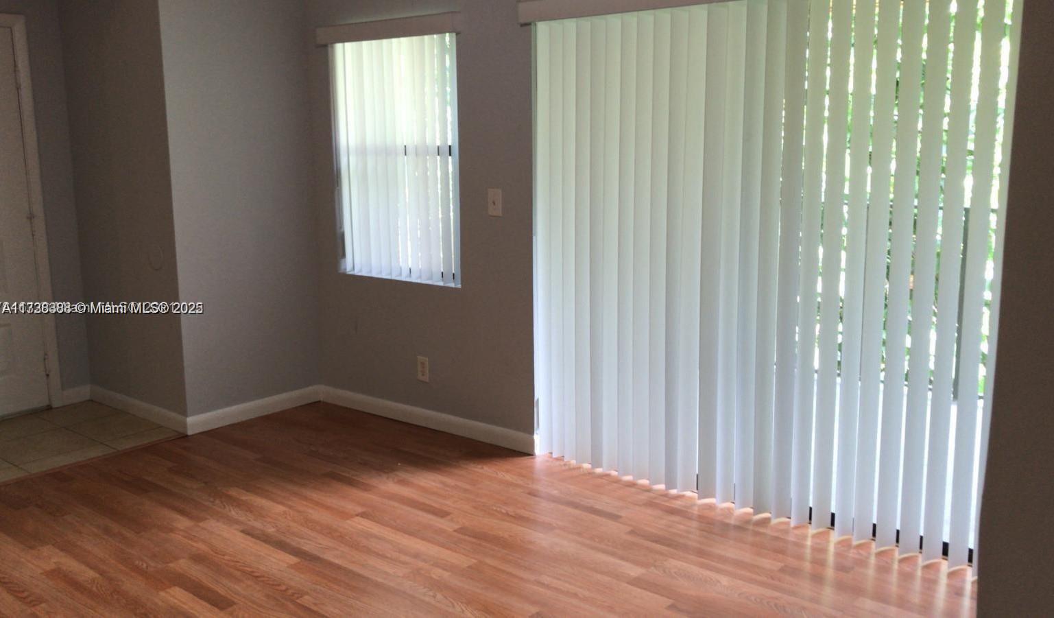 Summerbreeze Condominiums Sunrise, FL 33322 - Photo 9 of 12 a view of an empty room with wooden floor and a window