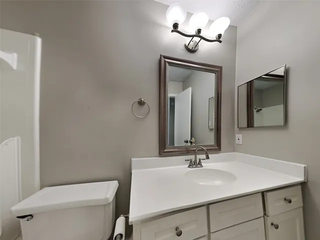 a bathroom with a toilet a sink and a mirror