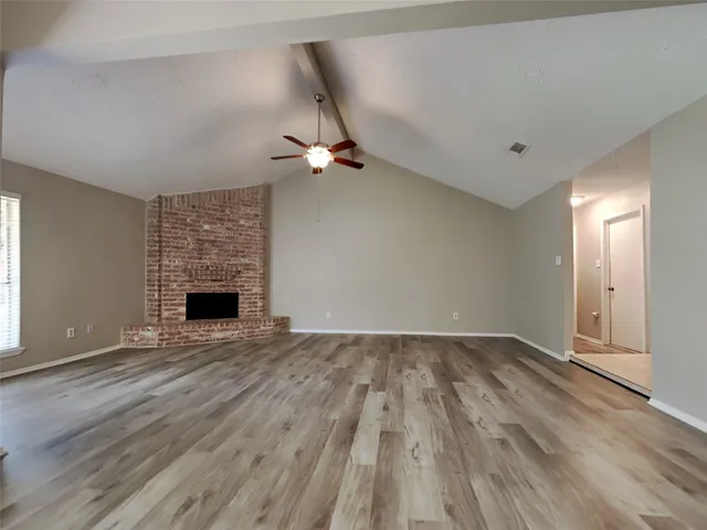 wooden floor in an empty room with a fireplace