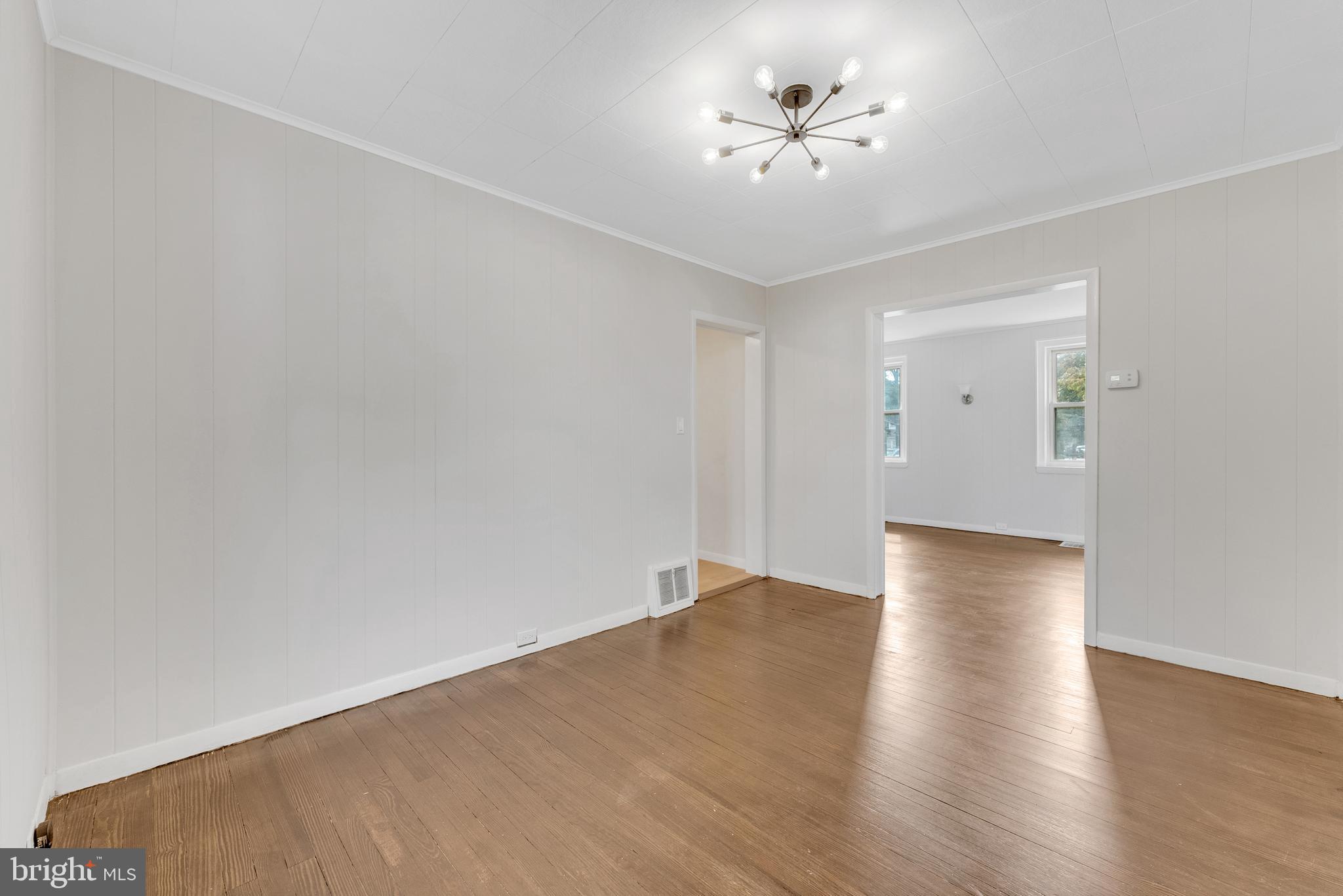 217 Pennsylvania Road Brooklawn, NJ 08030 - Photo 6 of 21 a view of an empty room with chandelier fan and wooden floor