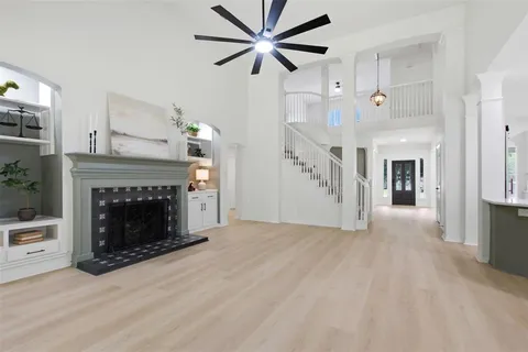 a view of a livingroom with a fireplace a ceiling fan a fireplace and windows