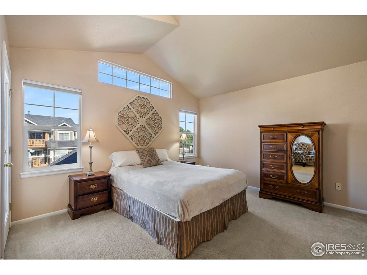 115 Bayside Circle Windsor, CO 80550 - Photo 11 of 23 a bedroom with a bed a mirror and a window