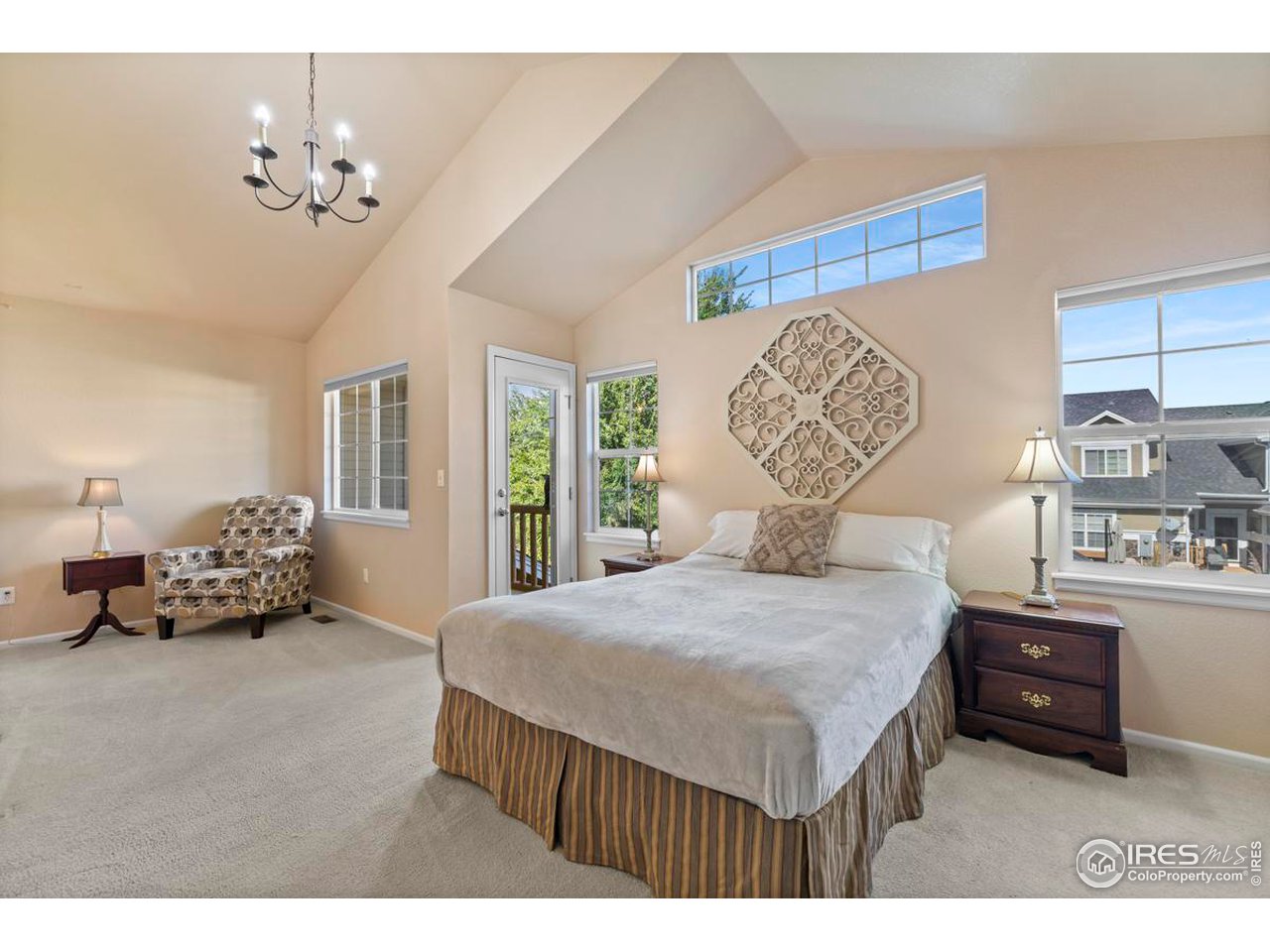 115 Bayside Circle Windsor, CO 80550 - Photo 12 of 23 a spacious bedroom with a bed and a chandelier