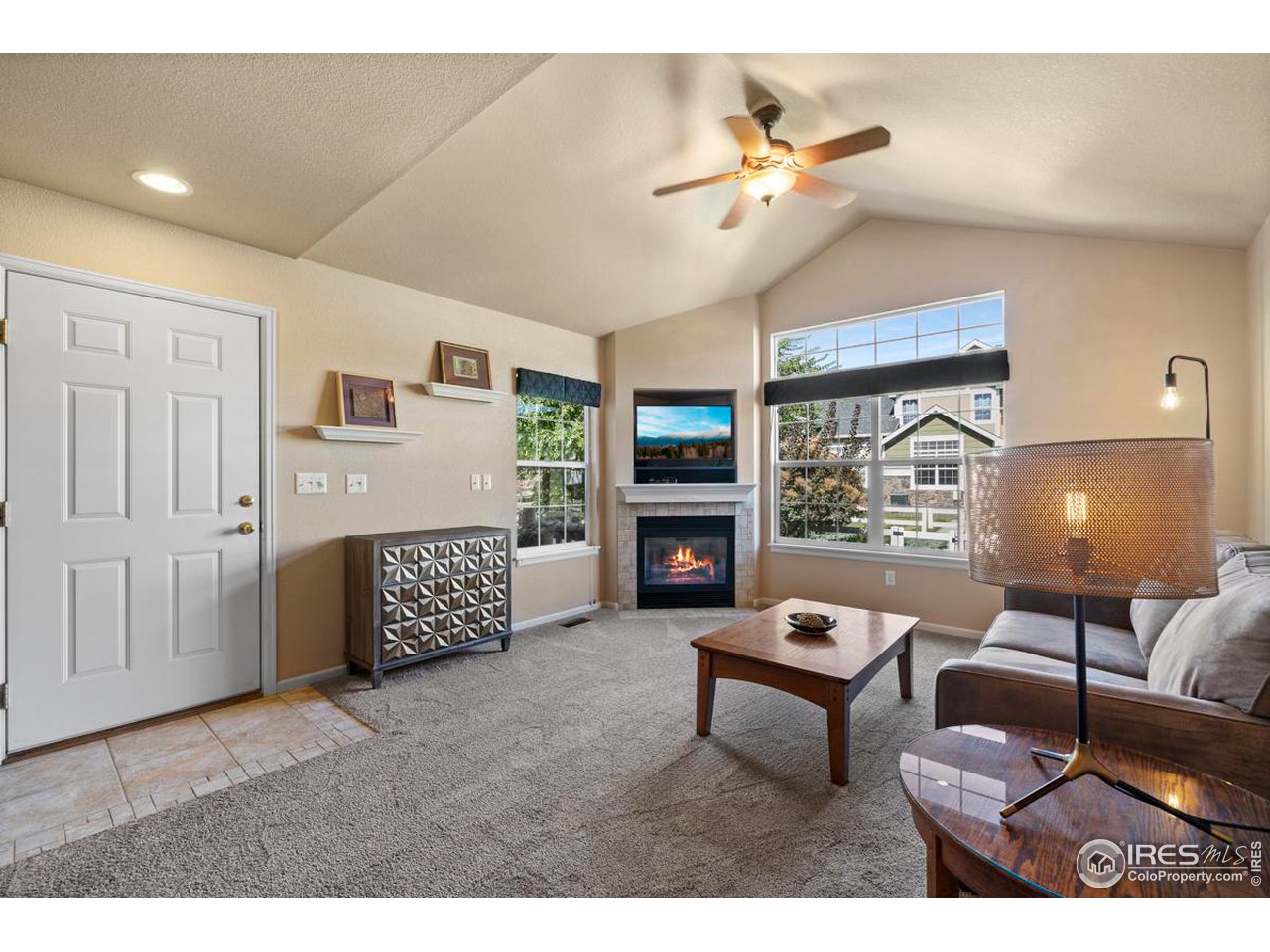115 Bayside Circle Windsor, CO 80550 - Photo 3 of 23 a living room with furniture a fireplace and a chandelier