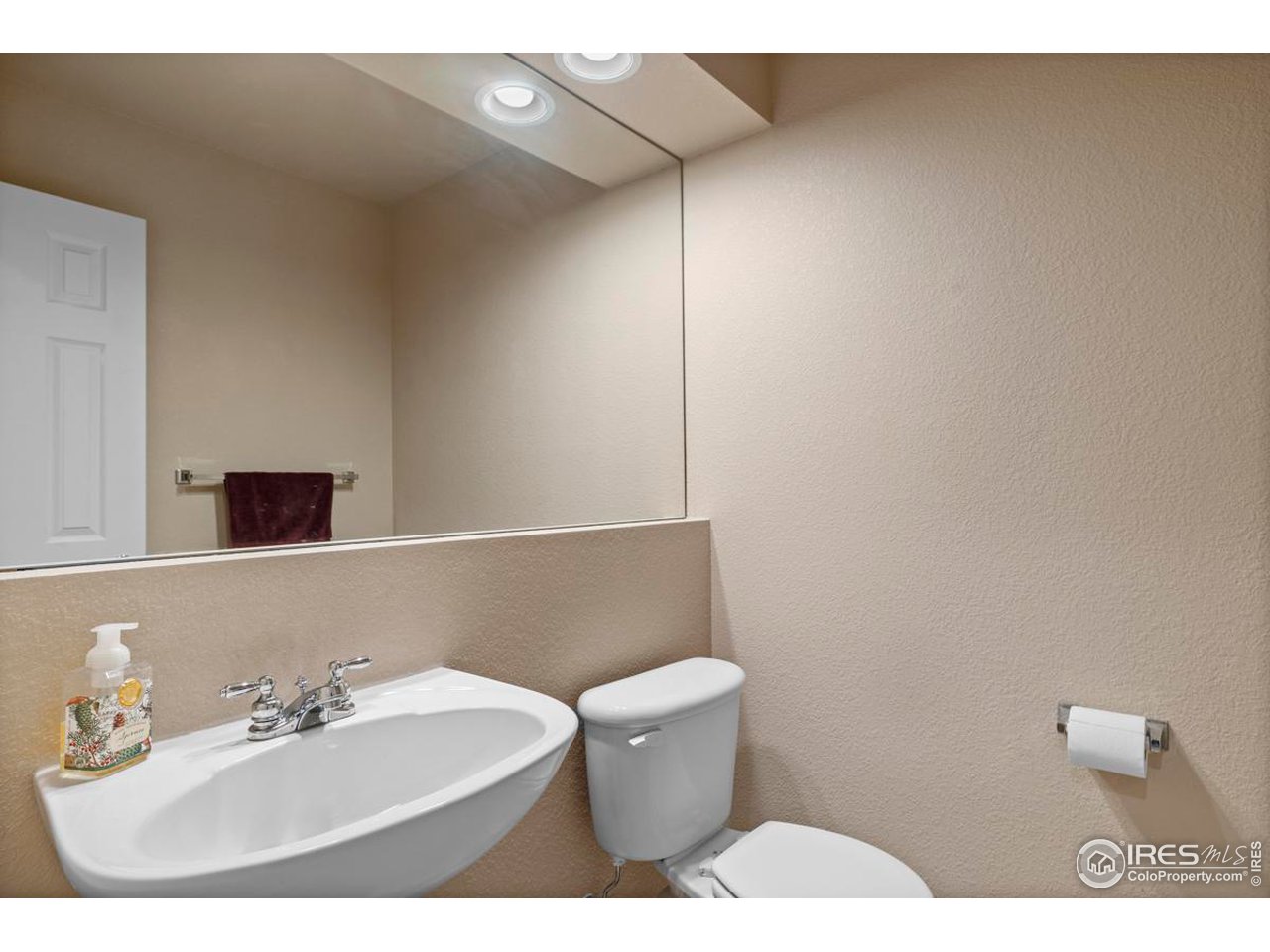 115 Bayside Circle Windsor, CO 80550 - Photo 10 of 23 a bathroom with a sink a toilet and mirror