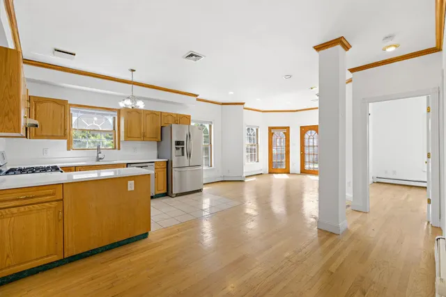 a large kitchen with lot of counter space and wooden floor