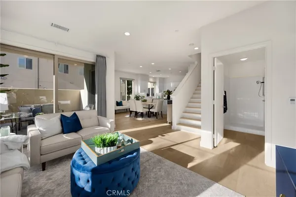 a living room with furniture a flat screen tv and a potted plant
