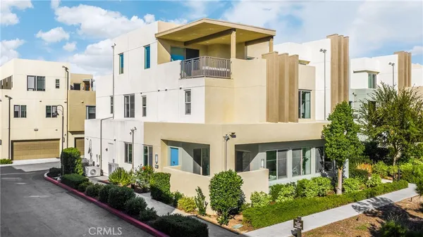 a front view of a multi story residential apartment building with yard and parking space