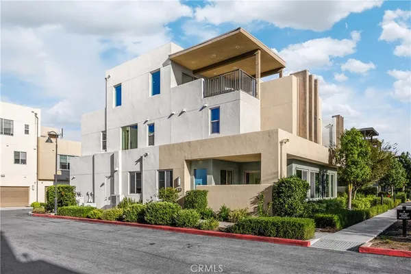 a view of a white house with a yard and potted plants