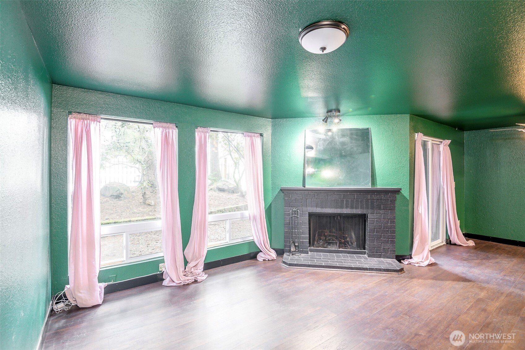 110 Southwest 116th Street, Unit A13 Seattle, WA 98146 - Photo 3 of 16 an empty room with wooden floor fireplace and a window