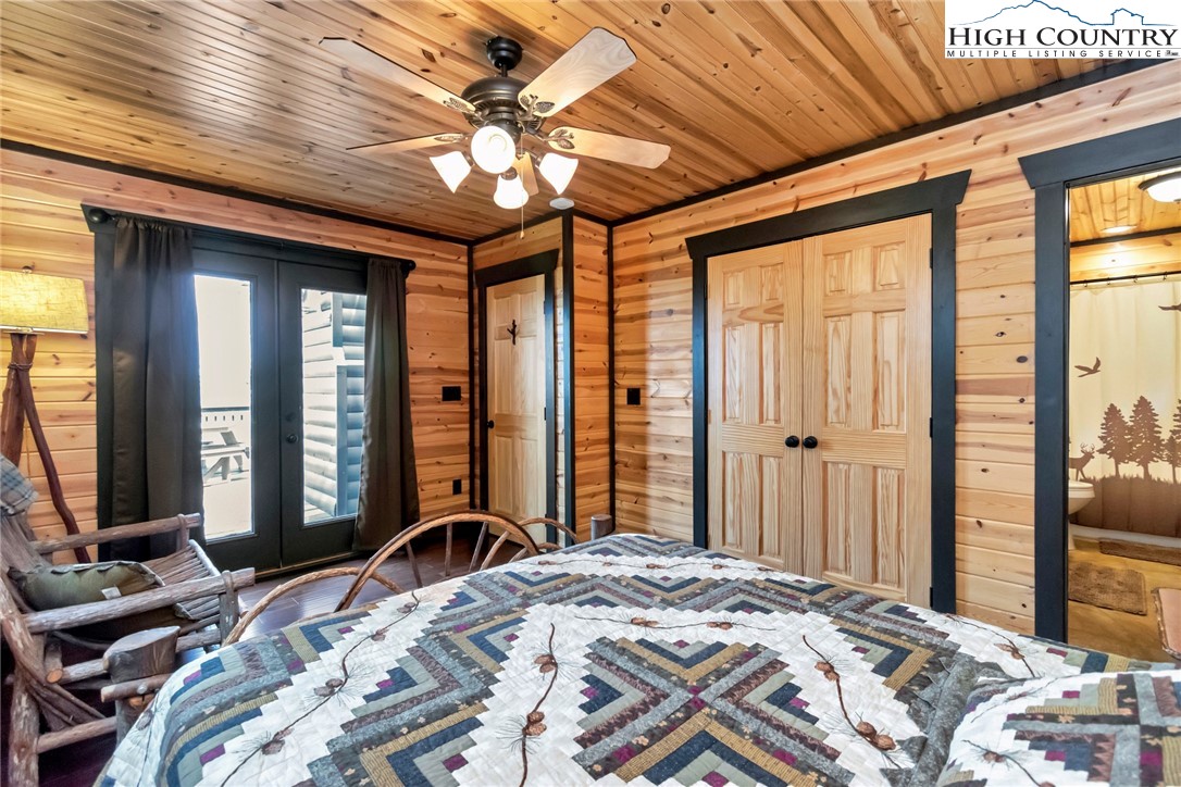 4879 Staghorn Road Purlear, NC 28665 - Photo 17 of 50 a bedroom with a large bed and a chandelier