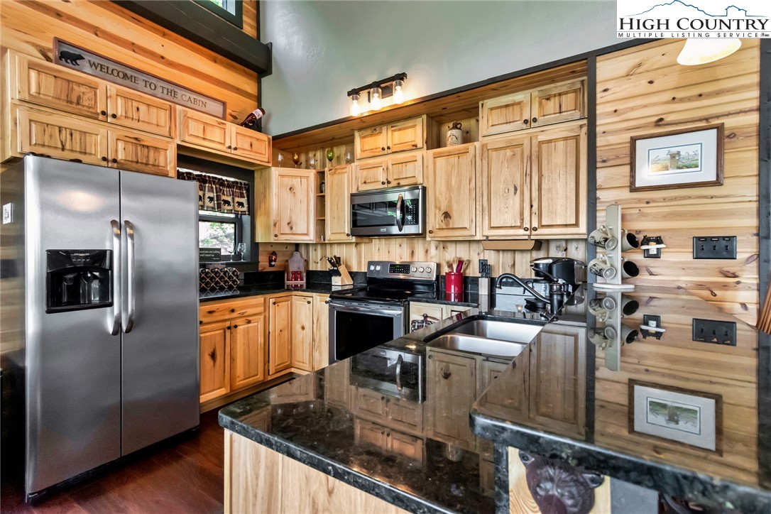 4879 Staghorn Road Purlear, NC 28665 - Photo 23 of 50 a kitchen with stainless steel appliances granite countertop a refrigerator a stove and a sink with wooden floor