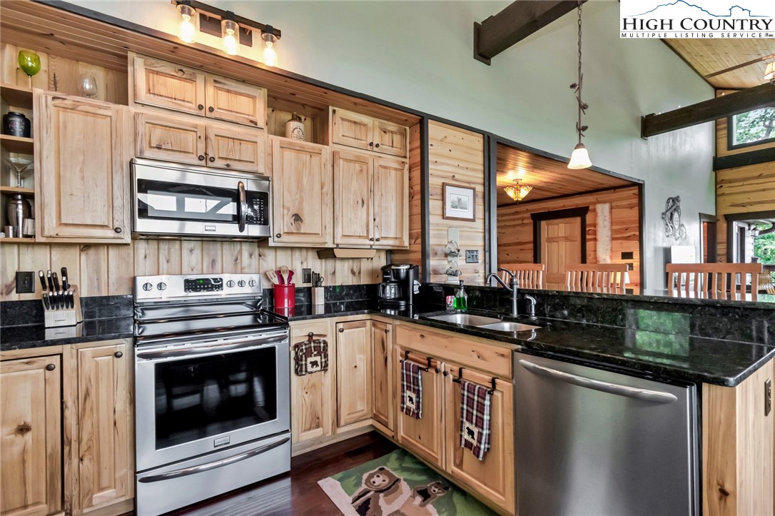 4879 Staghorn Road Purlear, NC 28665 - Photo 25 of 50 a kitchen with stainless steel appliances granite countertop a stove sink and cabinets