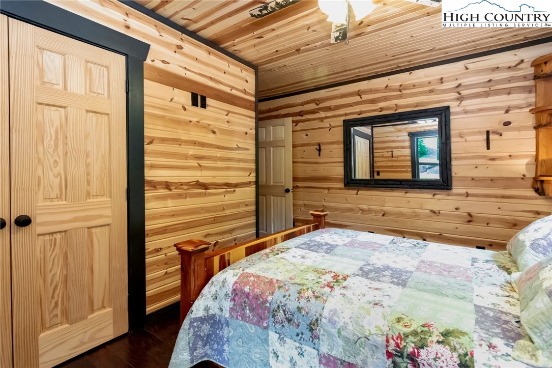 4879 Staghorn Road Purlear, NC 28665 - Photo 30 of 50 a view of a bedroom with wooden floor and a bed