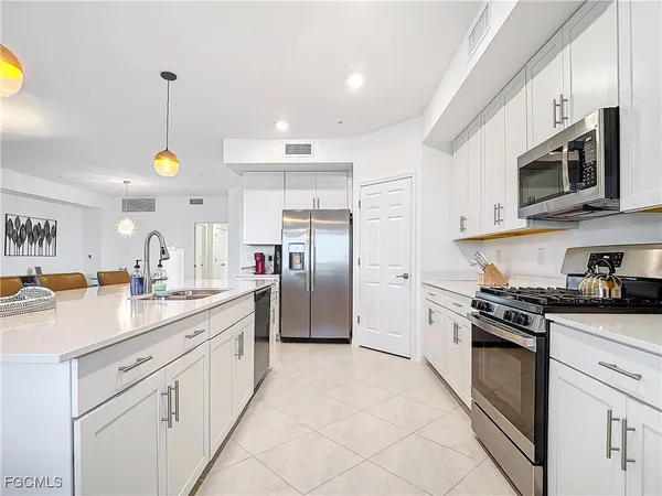 a kitchen with stainless steel appliances granite countertop a sink a stove and a refrigerator