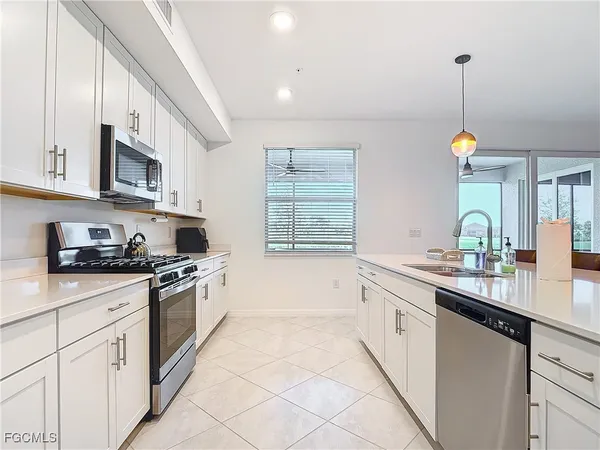a kitchen with granite countertop a sink a stove and cabinets