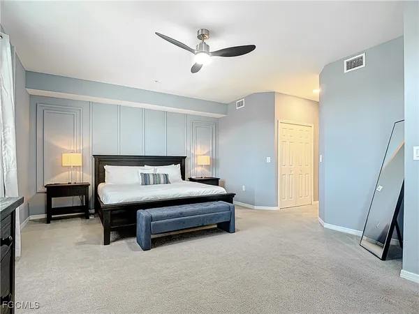 a spacious bedroom with a bed and a ceiling fan