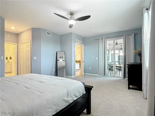 a spacious bedroom with a large bed and a chandelier