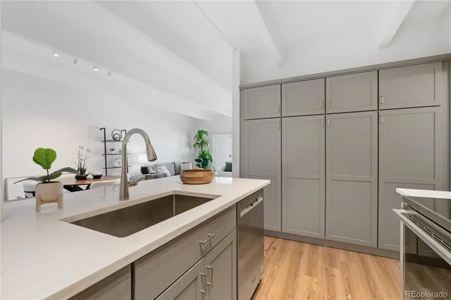 a kitchen with a sink cabinets and wooden floor