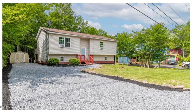 a view of a house with backyard and a tree