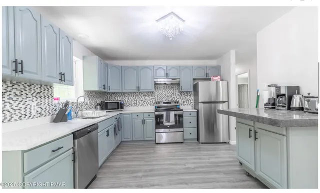 a kitchen with a sink cabinets stainless steel appliances and a window