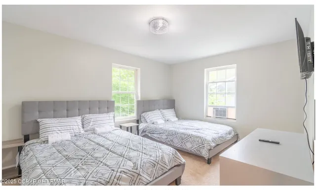 a bedroom with two beds and a window