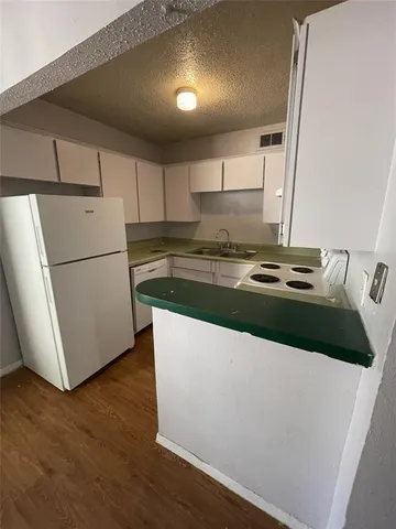 a kitchen with a refrigerator and a stove top oven