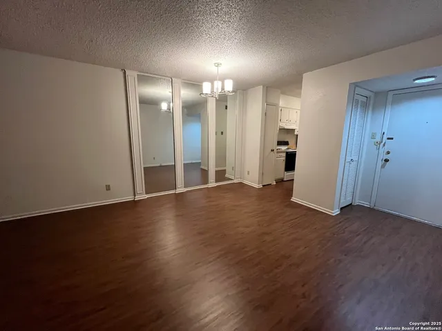 a view of a big room with wooden floor and windows