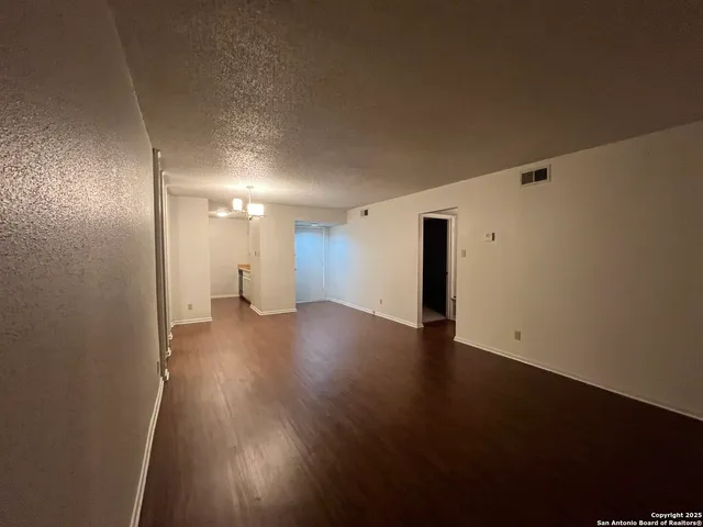 a view of a room with wooden floor